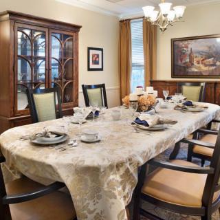 A beautifully set dining table in an elegant dining room with a china cabinet and chandelier.