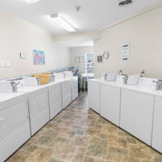 A bright and organized laundry room featuring multiple washing machines.