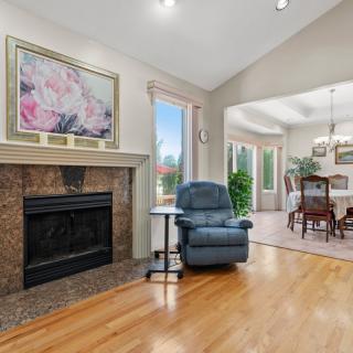 A cozy living room with a fireplace and an adjacent dining area.