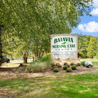 Entrance sign of Batavia Nursing Care surrounded by greenery.