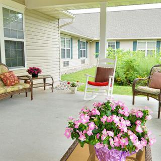 A cozy porch with comfortable seating and vibrant flowers.