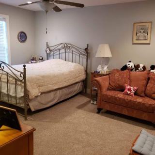 A cozy bedroom with a metal bed frame and a sofa.