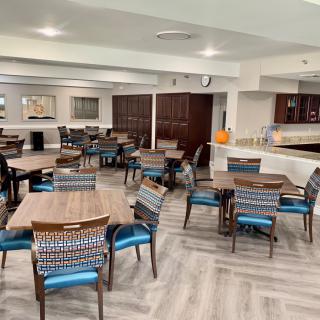 A modern dining area with neatly arranged tables and chairs.