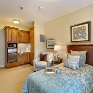 A cozy bedroom with a kitchenette and elegant decor.