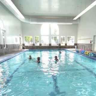 A group of people enjoying a swim in an indoor pool.