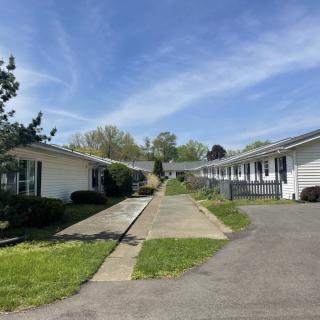A quiet motel with a central driveway under a clear blue sky.