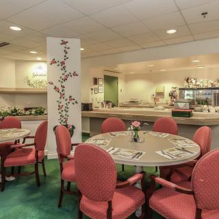 A cozy restaurant dining area with round tables and red chairs, offering an inviting atmosphere.