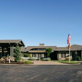 A residential building with a landscaped entrance and an American flag.