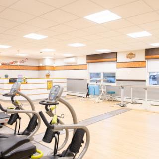A bright and spacious gym area equipped with exercise machines, perfect for workouts.