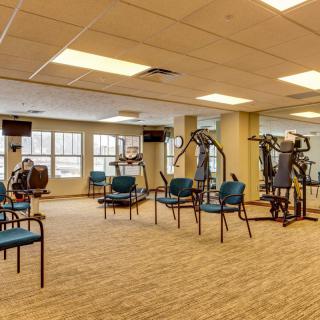 A well-equipped fitness center with various exercise machines and seating areas.
