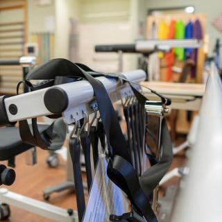 A physical therapy room featuring various exercise equipment and straps for rehabilitation exercises.