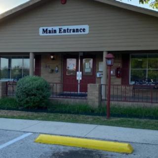The main entrance of a small building with a sign overhead.