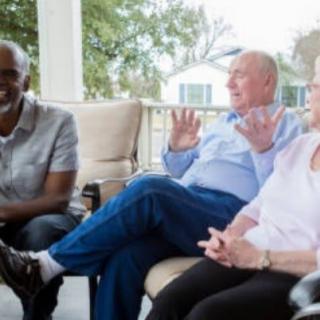 A group of people having a conversation on a patio.