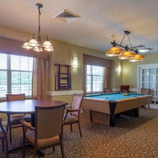 A spacious game room featuring a billiards table and seating area.