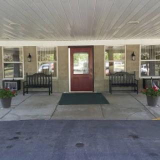 A welcoming entrance with benches and planters along the pathway.
