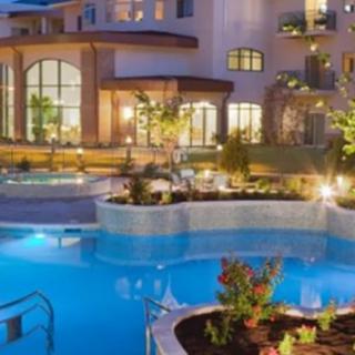 Luxurious hotel with a beautifully illuminated swimming pool at night.