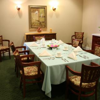 A formal dining room setup with a large table, chairs, and elegant decor.
