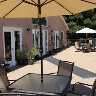A sunny patio area featuring tables and chairs with umbrellas.