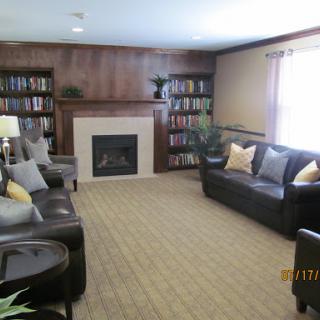 A cozy living room featuring a fireplace and bookshelves filled with books.