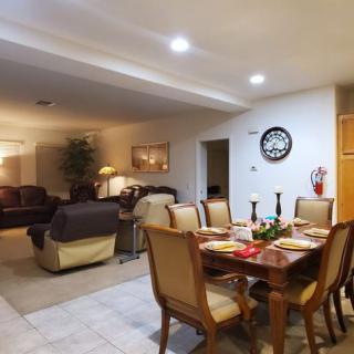 A cozy living room with a dining area featuring elegant furniture and soft indoor lighting.