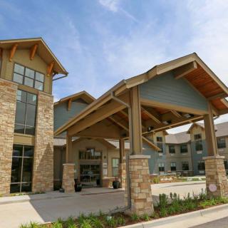 A modern commercial building with a stone facade and large entrance canopy.