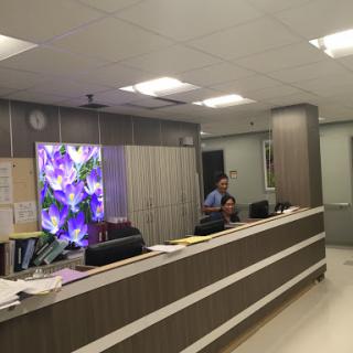 A modern office reception area with staff attending to visitors.