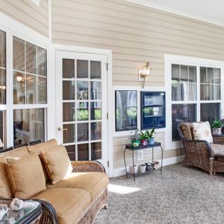 A bright and inviting sunroom with comfortable seating and large windows.