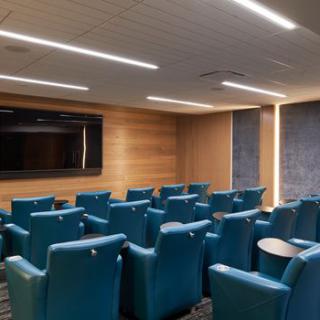 A modern conference room with theater-style seating and audiovisual equipment.