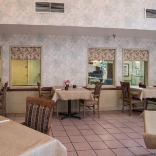 An empty restaurant dining area with neatly arranged tables and chairs.