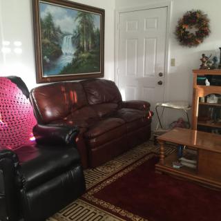 Cozy living room with leather furniture and a landscape painting.