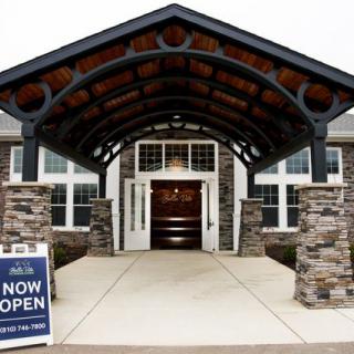 Entrance of a newly opened building with stone pillars and an awning.