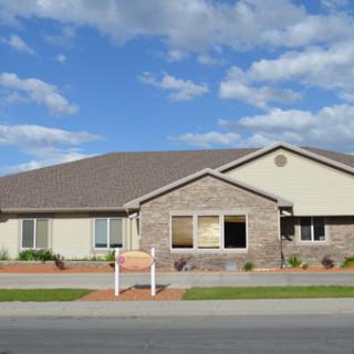 A well-maintained single-family home featuring a mix of brick and stucco with a landscaped front yard.