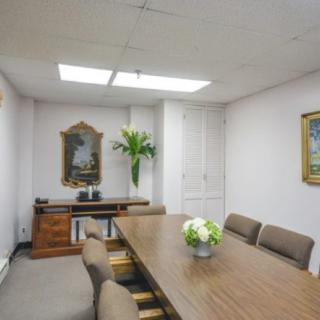 A well-decorated conference room with a long table, chairs, and floral arrangements.