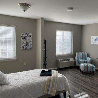 A modern, comfortable bedroom with large windows and cozy decor.