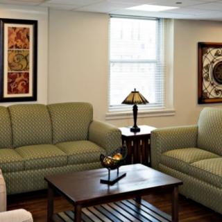 A cozy living room with two sofas, a wooden coffee table, and decorative wall art.