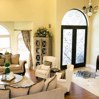 A stylish living room with elegant furniture and decor, featuring a seating area around a central coffee table.