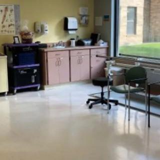 A hospital waiting room with chairs and medical equipment.
