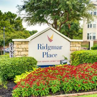 Entrance sign for Ridgmar Place surrounded by well-maintained landscaping and vibrant flowers.