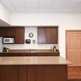 A modern kitchen with wooden cabinets and a spacious countertop.