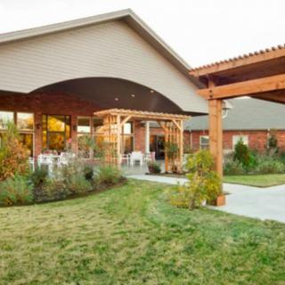 Modern building with a landscaped garden and outdoor patio area.