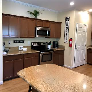 A modern kitchen with wooden cabinets and a central island featuring stainless steel appliances.