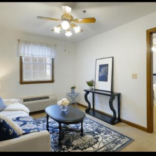 A cozy living room with a sofa, coffee table, and decorative artwork.