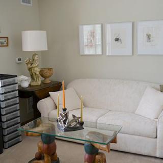 A cozy living room featuring a white sofa, glass coffee table, and elegant decor.