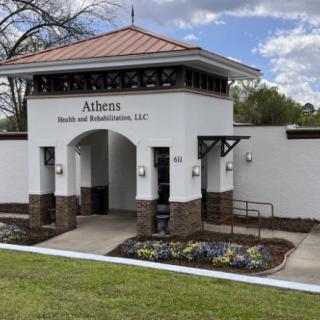 The entrance to a health and rehabilitation center, featuring landscaped flowers and architectural details.