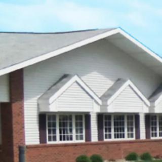 A residential building with a gabled roof and multiple windows.