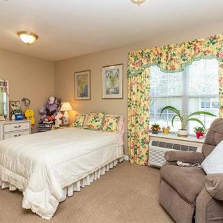 A cozy and decorated bedroom with floral curtains and comfortable furniture.