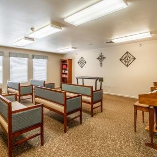 A small chapel interior with rows of benches and decorative wall elements.