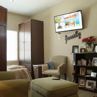 A cozy living room with a wall-mounted television and personalized decor.