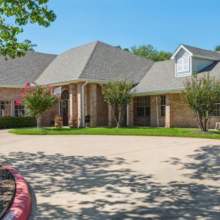 A suburban house with a wide driveway and well-maintained front yard.
