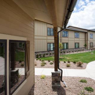 Exterior view of a two-story building with landscaped grounds and a pathway.